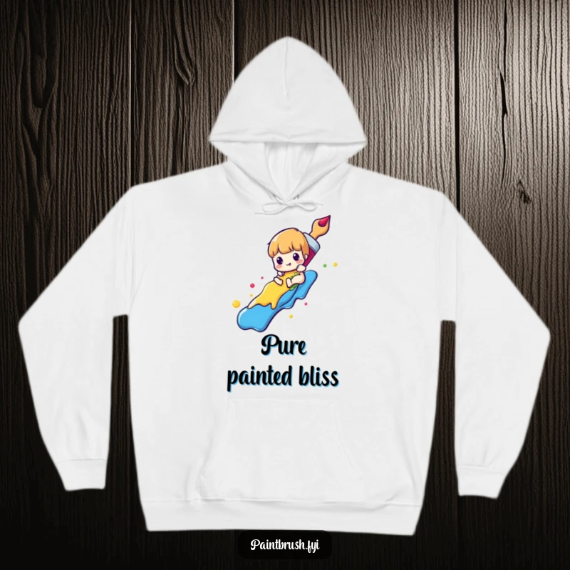 Funny paintbrush hoodie featuring a character sliding down a rainbow of colorful paint, offering cozy artistic fun and humor.