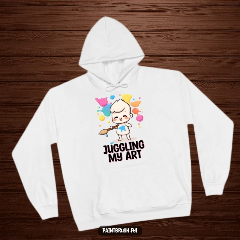 Funny hoodie illustration of a paintbrush character impressively juggling a rainbow of paint blobs, ready for action.